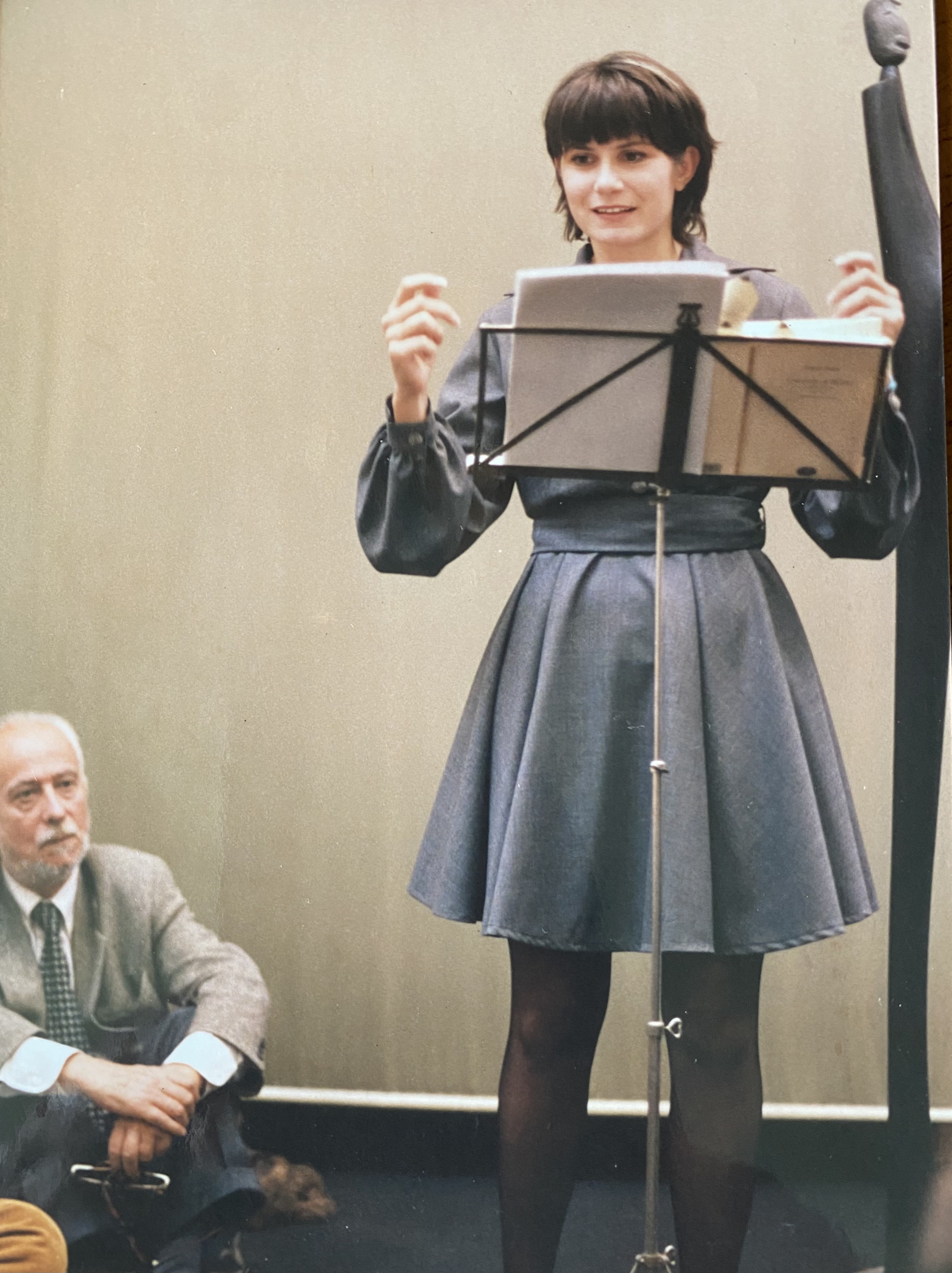 Chiara Bazzoli legge al leggio in una galleria d'arte milanese durante Non dimenticare il tuo cuscino, 1996
